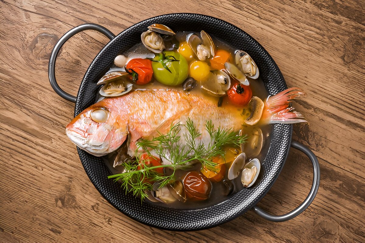 Cooked red snapper served with lemon, herbs, and vegetables, highlighting healthy cooking tips.